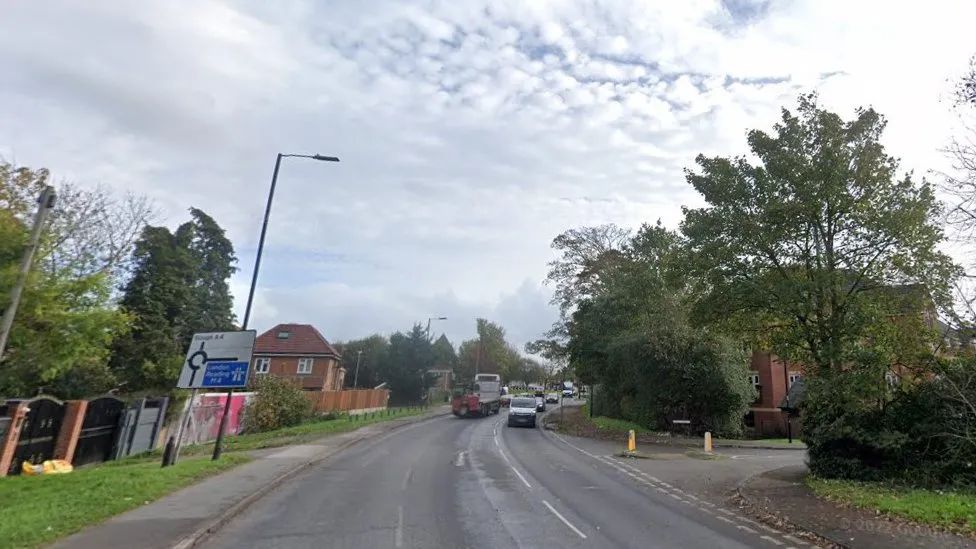 A Google Maps picture of the A4 in Slough, with a road sign showing that carrying on would take you to Slough and the M4 if you drive to the right at an upcoming roundabout. Trees, grass and pavements run alongside the road