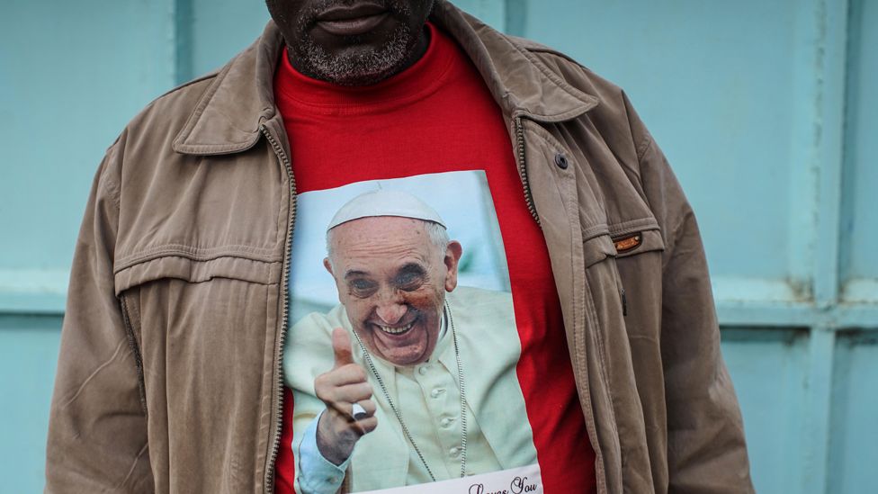 Father Paschal Mwijage of the St. Joseph the Worker Parish in Nairobi"s Kangemi slum wears a t-shirt of Pope Francis on November 24, 2015 in Kenya.