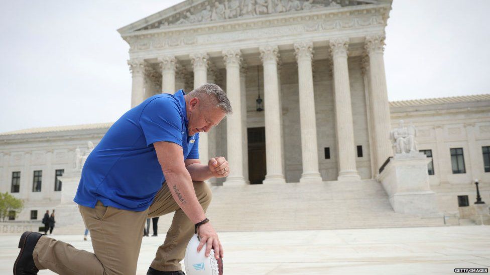 Former high school American football coach Joseph Kennedy prays in front of the Supreme Court