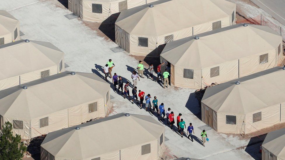 People walking outside tents in Tornillo, Texas