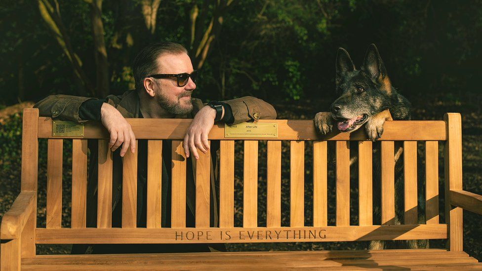 Ricky Gervais and dog with bench