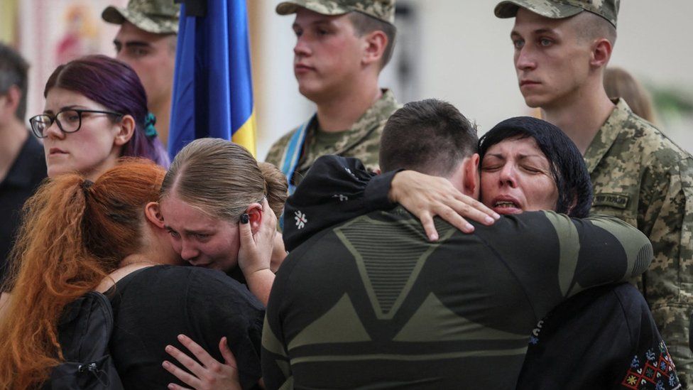 Партнерша Андрея Пищикова (вторая слева) и мать (справа) реагируют на его панихиду в Киеве, Украина. Фото: 29 августа 2023 г.