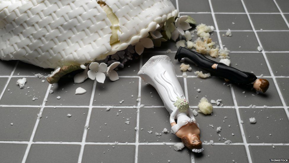 broken wedding cake on floor with figurines smashed