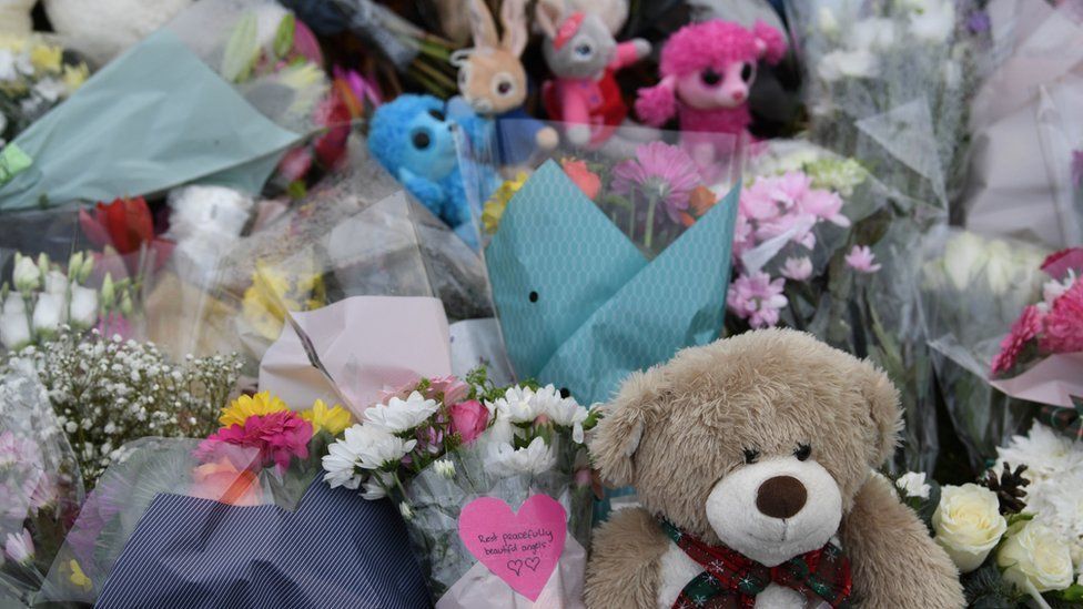 A close-up of flowers and soft toys left in memory of two children who died in a house fire, Eynesbury, Cambridgeshire