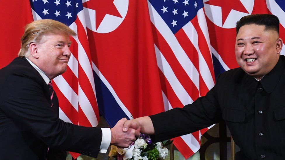 US President Donald Trump (L) shakes hands with North Korea's leader Kim Jong Un
