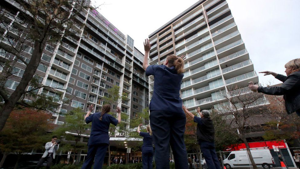 Nurses wave to residents in a Melbourne quarantine hotel