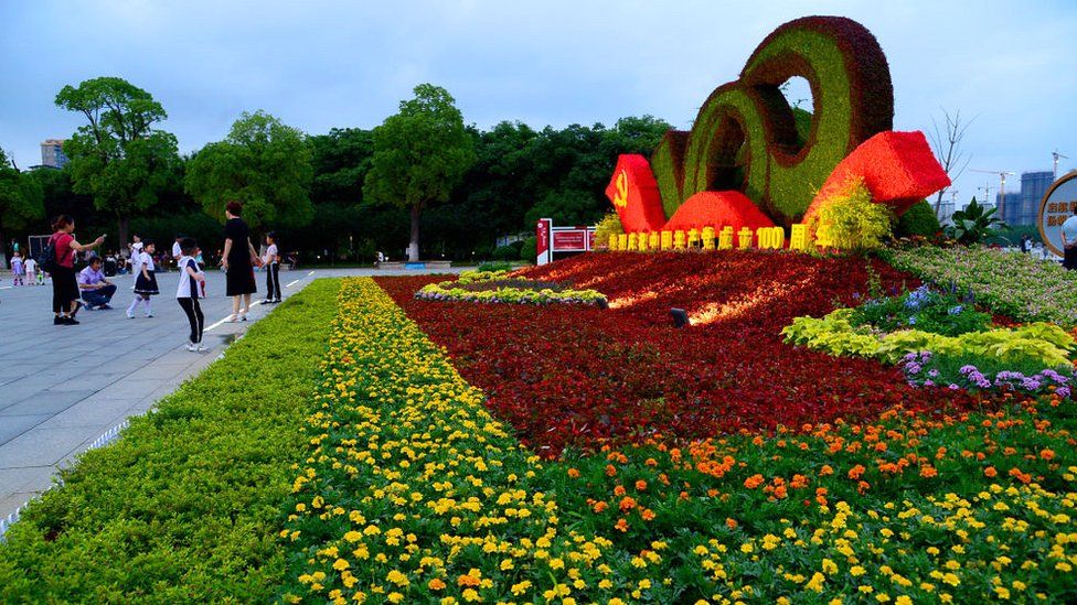 Клумба с темой празднования 100-летия основания Коммунистической партии Китая привлекает жителей города Тайцан, провинция Цзянсу на востоке Китая, для фотографирования 30 июня 2021 года