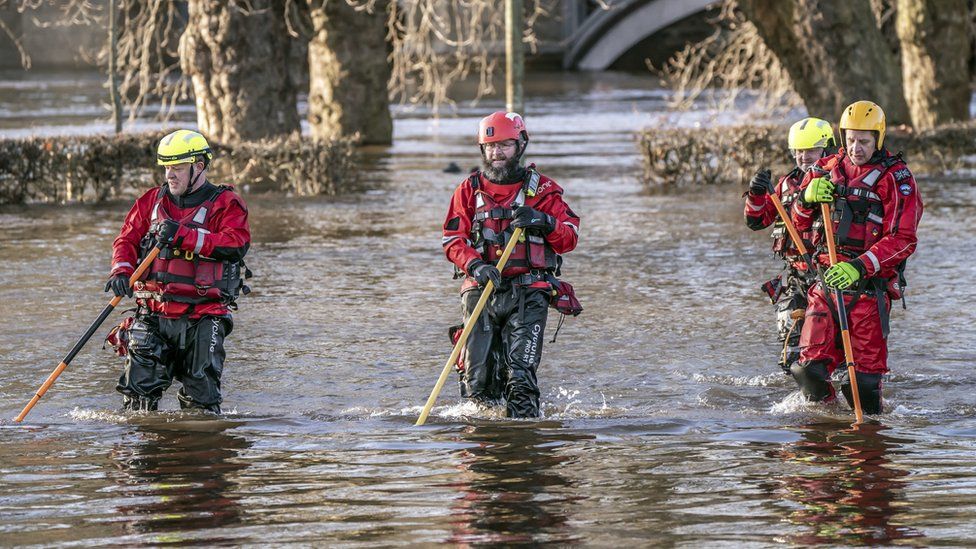 Rescue workers wade through York after the River Ouse burst its banks