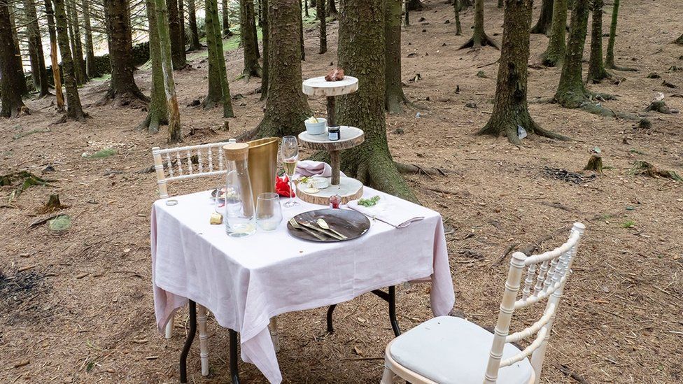 Table and two chairs with afternoon tea in wooded area at Blea Tarn