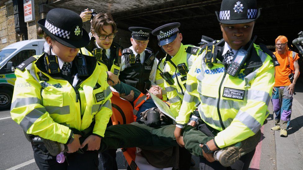 Police detain a Just Stop Oill activist during a slow walk protest in Vauxhall, central London