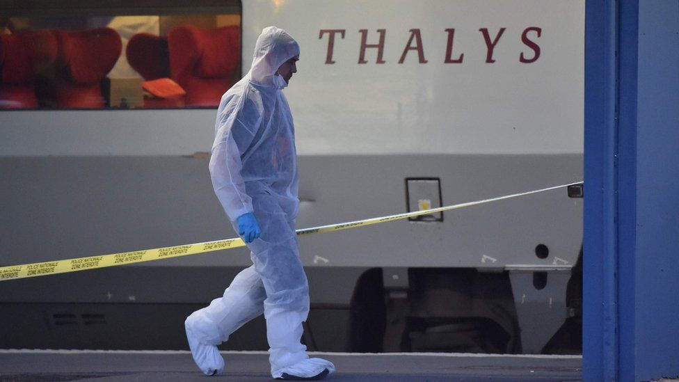 A man in a forensic suit walks near the crime scene in front of a Thalys train in August 2015