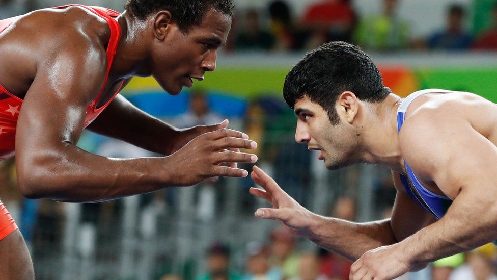 In this file photo taken on August 20, 2016 shows USA's J'den Michael Tbory Cox (red) wrestling with Iran's Alireza Mohammad Karimi Mashiani during the wrestling event of the Rio 2016 Olympic Games