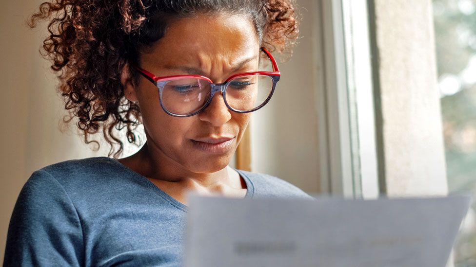 Stock image of a woman looking at a bill