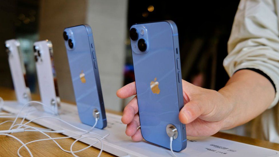 A customer picking up a sample iPhone 14 in an Apple store in China.