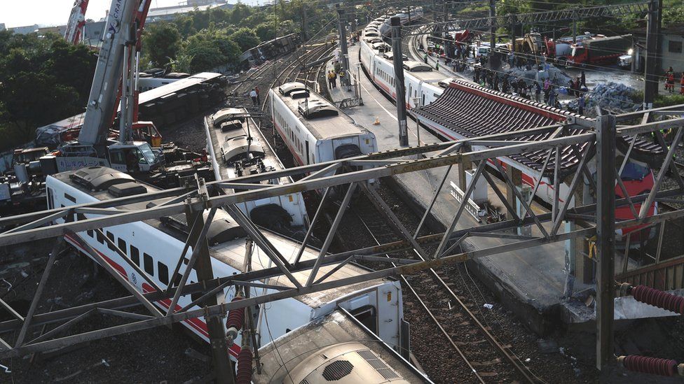 Rescuers use a crane to remove a derailed train at the site of the accident in Yilan,