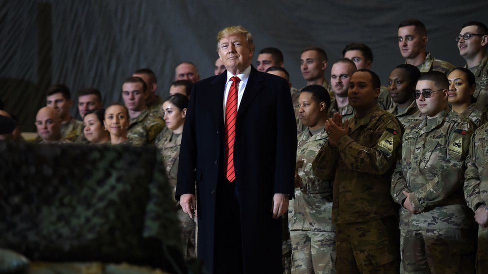 Donald Trump with army personnel standing behind him in Afghanistan