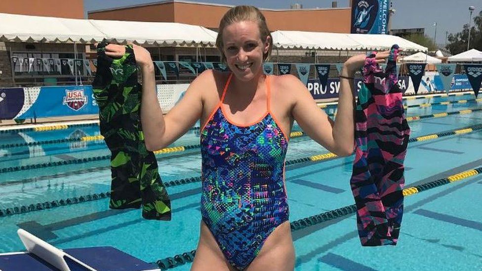 Swimmer Dana Vollmer holding green and pink swimming costumes - 13 April 2017