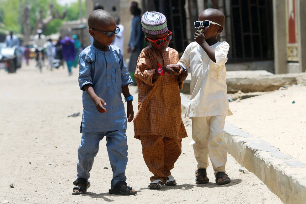 Three boys in Eid outfits and sunglasses in Maiduguri, Nigeria - Monday 2 May 2022