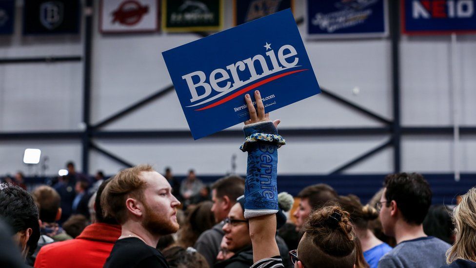 Bernie sanders supporter with a cast holding Bernie sign
