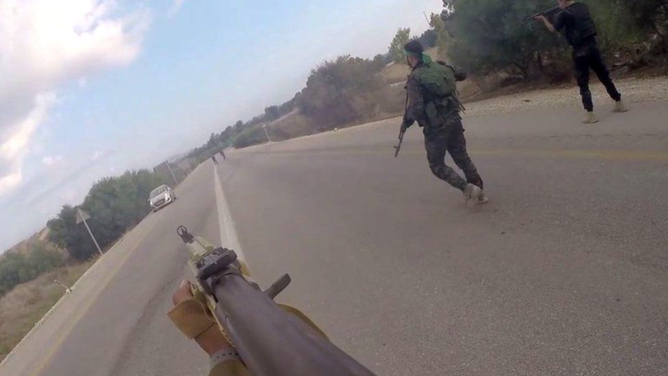 Still from video showing Hamas militants point gun at car on road