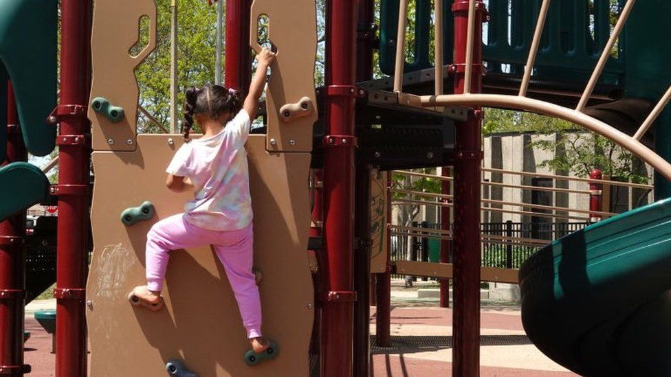 A migrant girl who arrived with her family from Venezuela plays in a Chicago playground