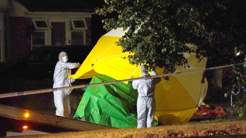 A mobility scooter is loaded on to a truck at the scene in Cayton Road, Greenford in west London, where an elderly man who had been riding a mobility scooter was stabbed to death