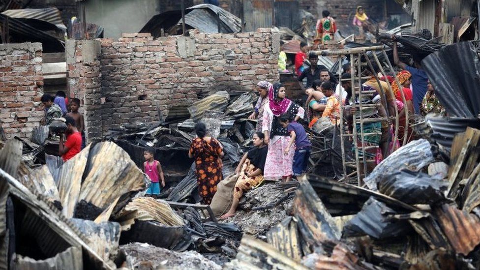 Slum dwellers are seen gather near their shelters after fire burnt them out in Dhaka, Bangladesh, on 17 August 2019