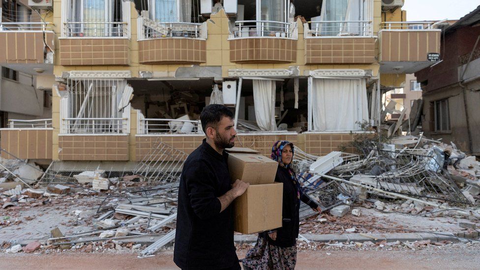 A man holds boxes to contain belongings gathered from their destroyed homes in the aftermath of the deadly earthquake in Antakya, Hatay province, Turkey