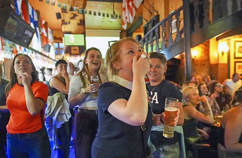 Football fans celebrate in a pub for England's fourth goal in the England v Sweden semi-final of the Women's Euros 2022