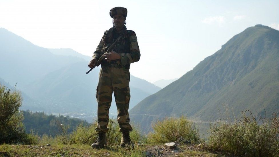 An Indian army soldier stands guard near the site of a gunbattle between Indian army soldiers and rebels inside an army brigade headquarters near the border with Pakistan, known as the Line of Control (LoC), in Uri on September 18, 2016.