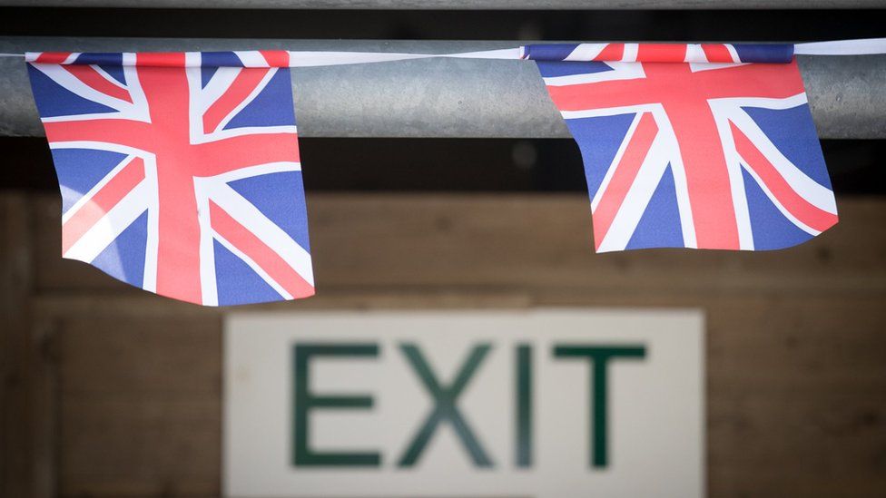 Union jack bunting hangs above an exit sign