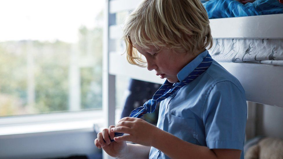 Boy tying school tie