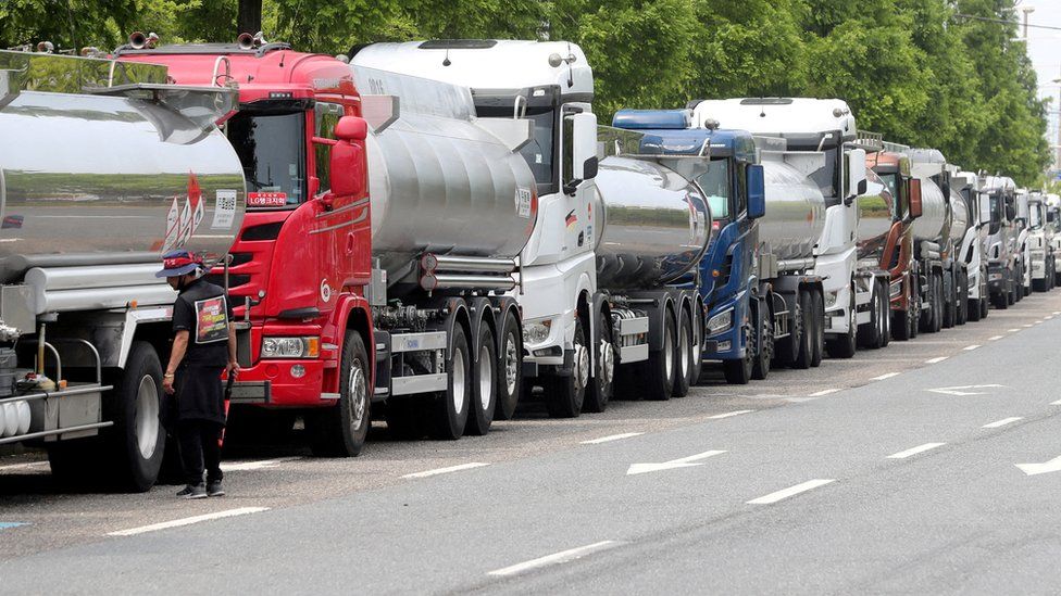 Член профсоюза Cargo Truckers Solidarity стоит рядом с грузовиком во время забастовки в Йосу, Южная Корея.