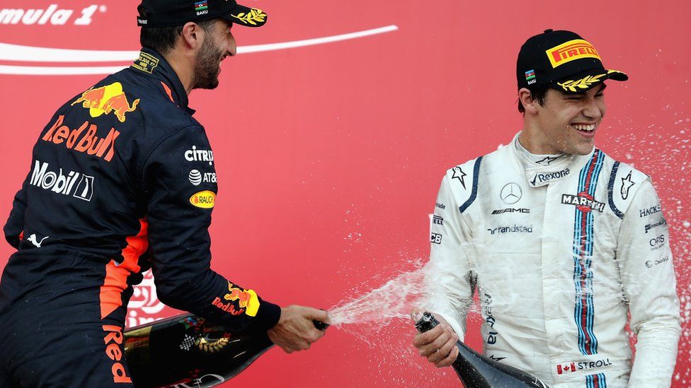 Lance Stroll sprays champagne on the podium with Daniel Ricciardo in Azerbaijan last season.
