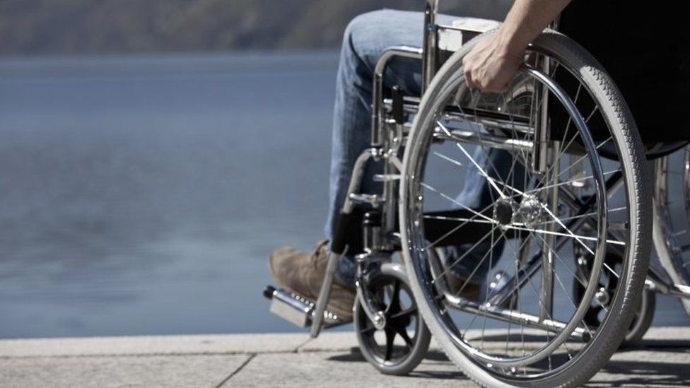 File photo of a man in a wheelchair sitting by water.