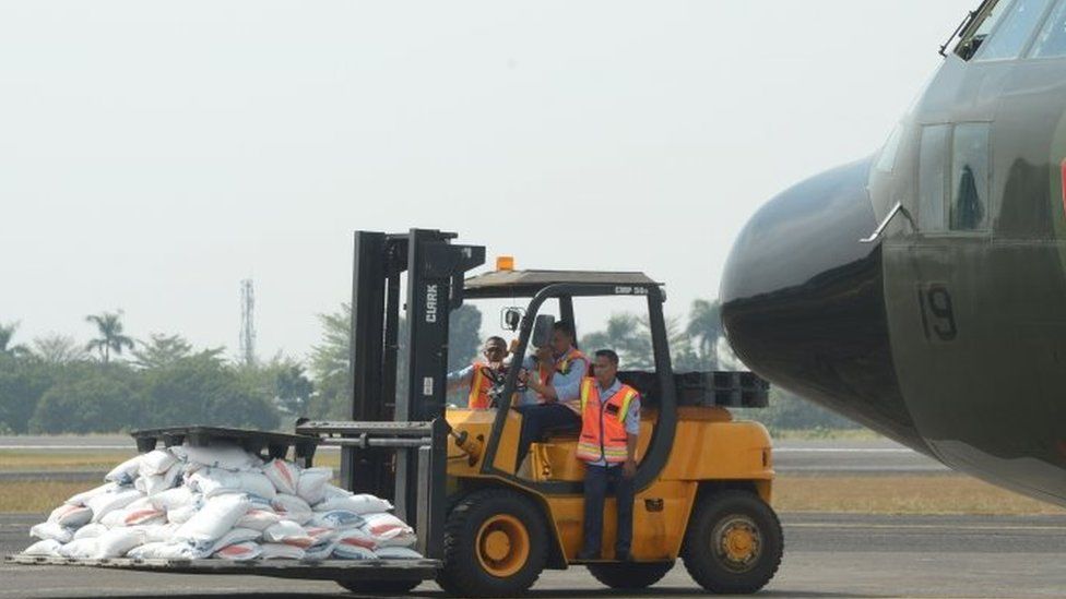 A forklift at the Halim Perdanakusuma airport in Jakarta ferries government food aid to an Indonesian air force C-130 aircraft bound for Bangladesh with its cargo for Rohingya refugees
