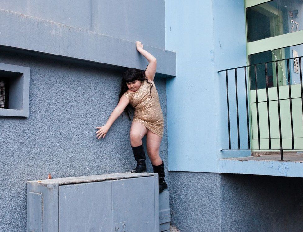 A girl climbs along a wall