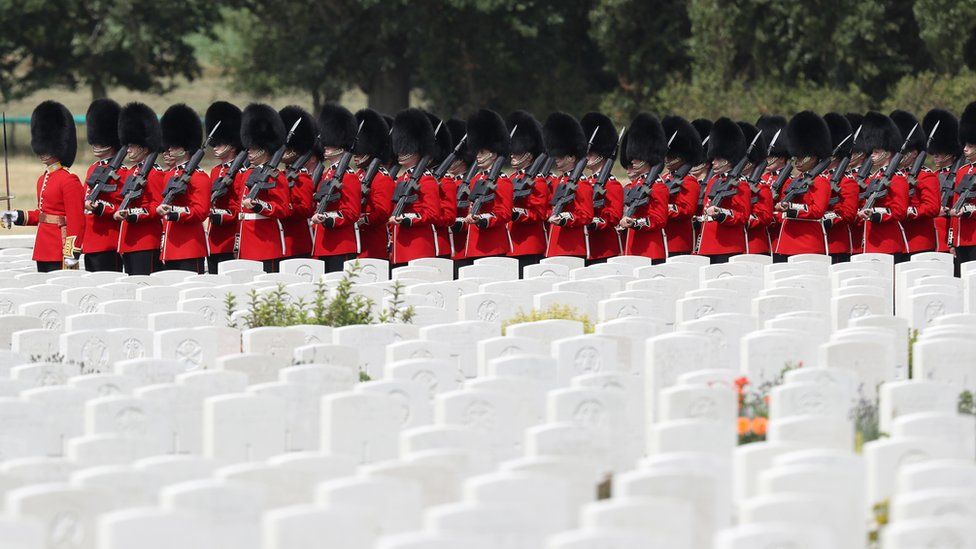 Members of the Queen's Guard march at the Tyne Cot cemetery