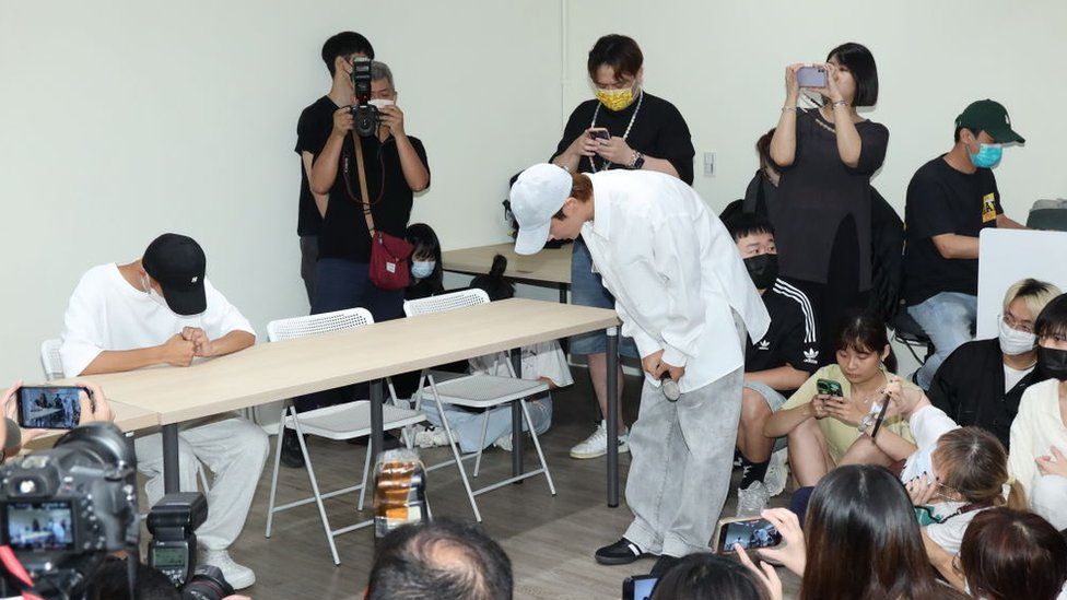 Actor Aaron Yan (R) apologises during a press conference held by internet celebrity Yao Le (L)