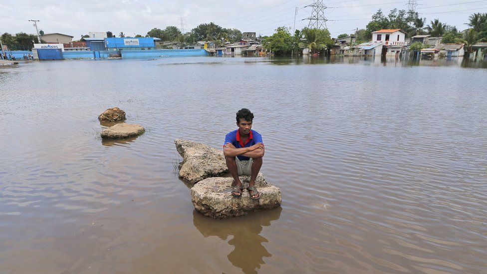 A Sri Lankan sits on a concrete slab in a flood affected area Colombo, Sri Lanka, Sunday, May 22, 2016