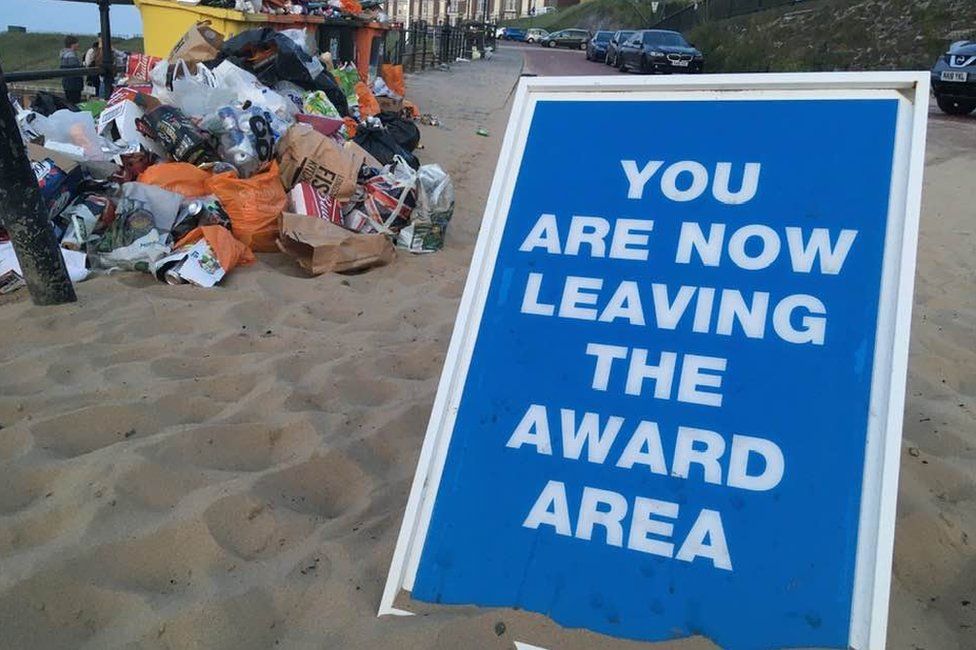 "Award Area" sign next to rubbish piled up by bins at Longsands beach, Tynemouth