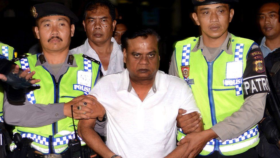 Индонезийская полиция сопровождает Чхоту Раджана из штаб-квартиры полиции Бали в аэропорт Нгурах-Рай во время его депортации из страны.