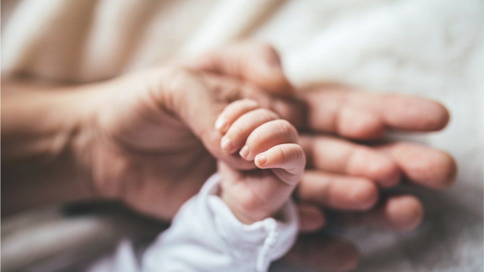 Holding a newborn's hand