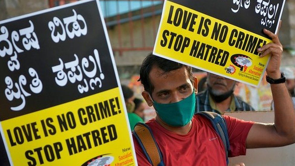 A civil right activist holds placards during a demonstration condemning the decision of various Bharatiya Janata Party (BJP) led state governments in the country for the proposed passing of laws against "Love Jihad"