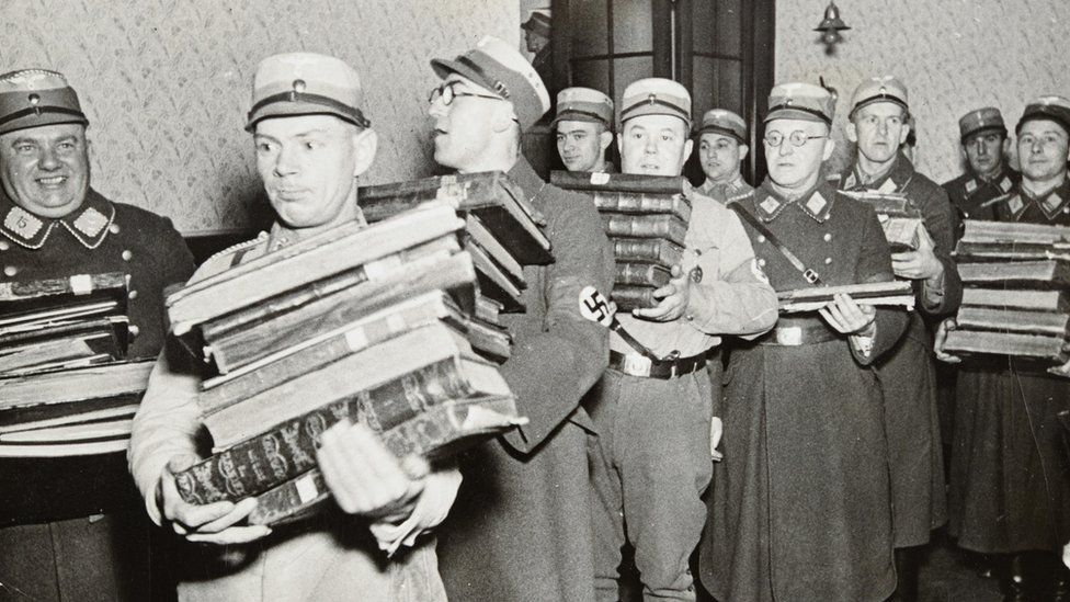 Нацистские чиновники уносят книги, предположительно для сожжения
