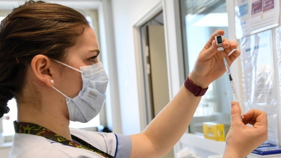 A healthcare worker prepares a dose of a Covid-19 vaccine near Paris
