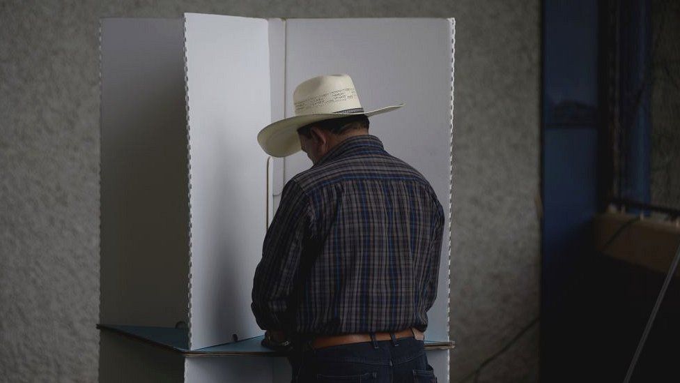 A Guatemalan man wearing a cowboy hat casts his cote in the August 2019 election