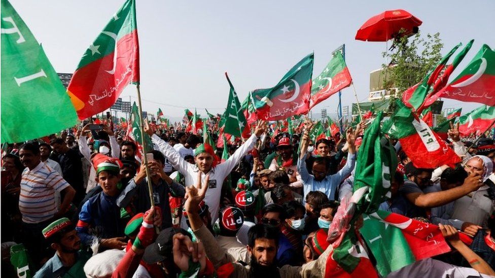 Сторонники премьер-министра Пакистана Имрана Хана, председателя политической партии Пакистан Техрик-и-Инсаф (PTI), размахивают флагами на публичном митинге в Исламабаде, Пакистан, 27 марта 2022 г.