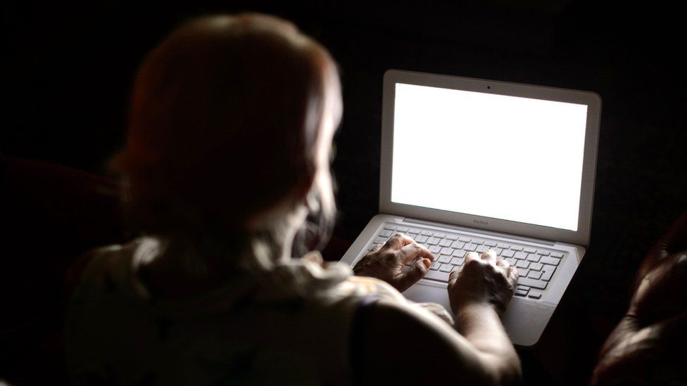 A woman looks at a computer screen