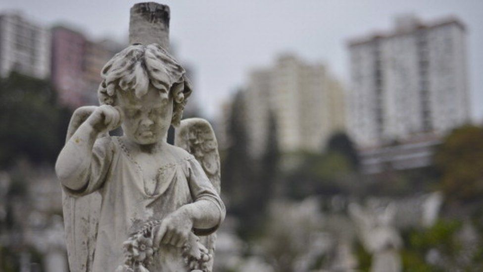Head stones adorn graves in a Roman Catholic cemetery below residential buildings in Hong Kong (18 December 2012)